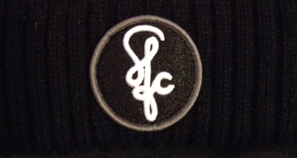 The logo used for Skate for Change. It is embroidered here into a hat, one of the many merchandise, that if purchased the profits go to the charity.