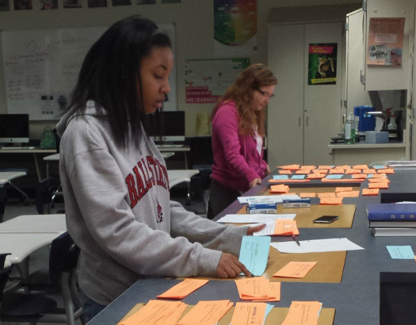 Juniors Tamera Sims and Audree Logan prepare reminder slips on May 5 for students who ordered yearbooks. Photo by Victoria Bernard.