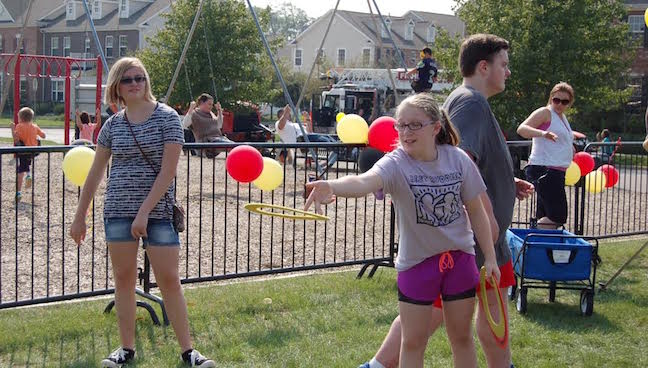 Sophomore Arianna Wityshyn assists fair goer with the outdoor games on Sept. 24 2016. Photo by Helen Rummel.
