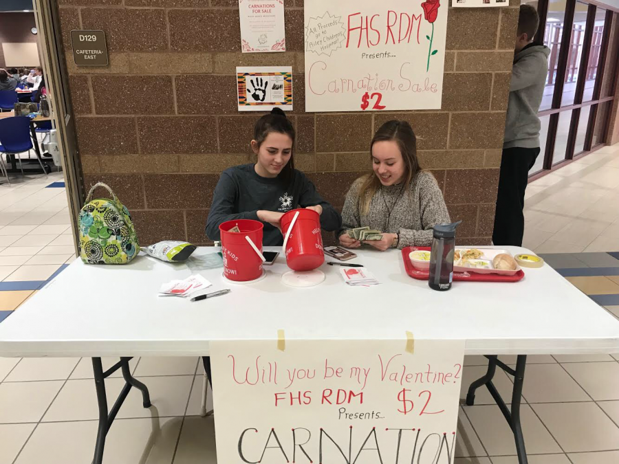 On Feb. 8, junior Lauren Nix and sophomore Brynn Roberts sell carnations for Riley alongside distributing  Fashion Show applications, showing how closely linked the Fashion Show and Dance Marathon are.