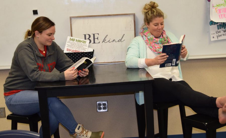 English teacher Bridgit Goss (right) reads Still Me by Jojo Moyes, with her teammate English teacher Haley Care (left) for the March Reading Madness competition. Photo by Lance Marshall on March 29. 