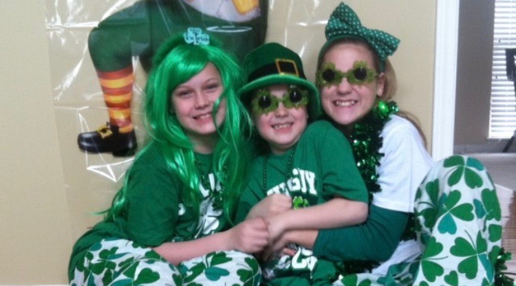 Dressed up in Saint Patricks day clothing, sophomore Mac McGuire poses for a photo with her siblings Kevin and Mary McGuire on Saint Patricks day 2014. Photo used with permission by Mac McGuire. 

