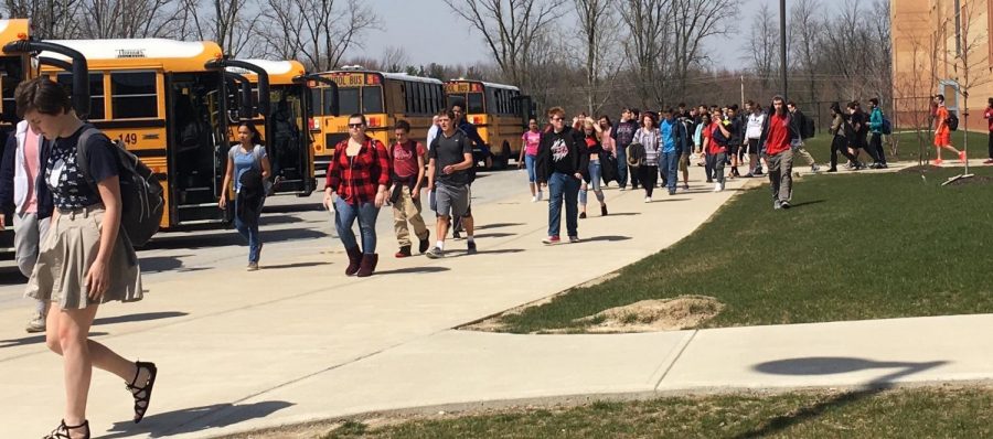 Students walk to the buses in the 70 degree weather on Thursday April 12. Photo by Hallie Gallinat.