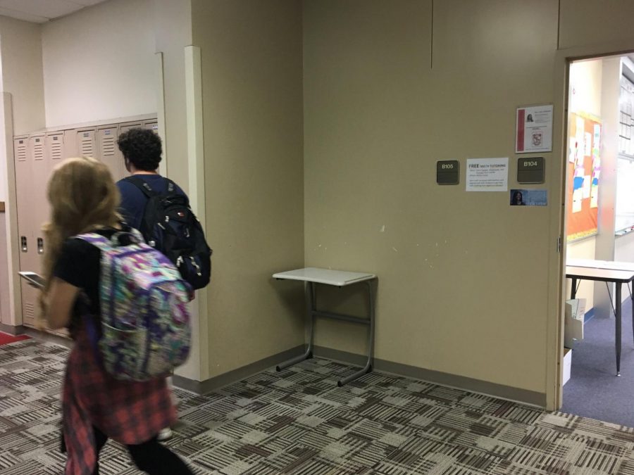 Students walk by B105, unaware of the full history of the room. 