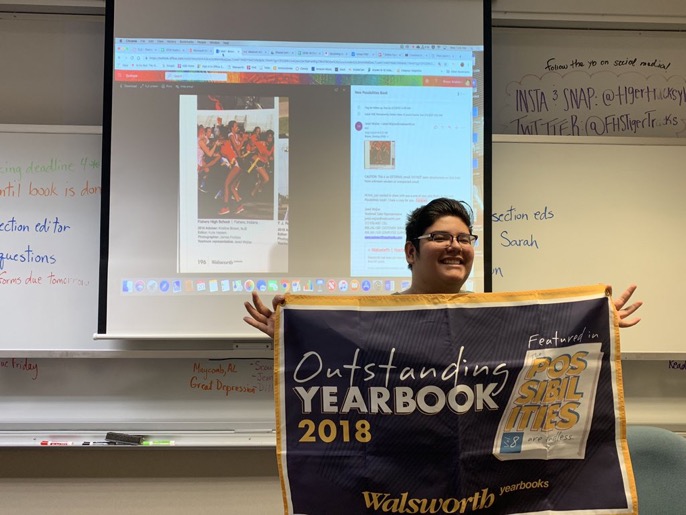 Junior James Fortozo accepts a banner commemorating his outstanding Yearbook page.