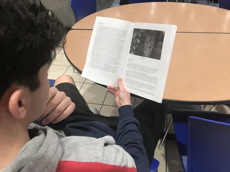 Junior Jackson Baumgartner reads a poem from last years Literary Magazine during study hall on March 14.