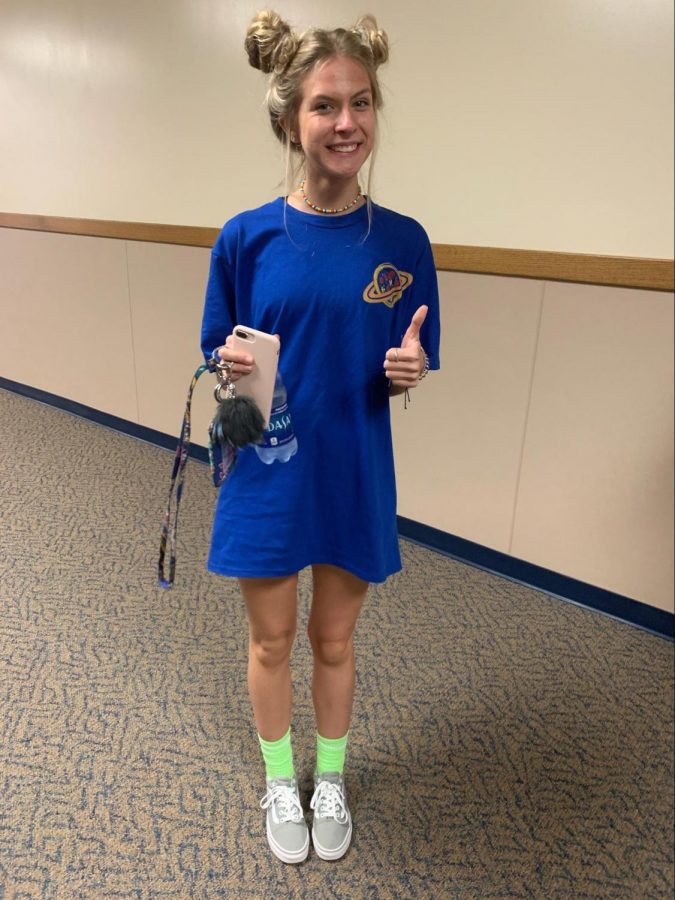 Junior Sedona Watson is wearing space buns which have been brought back since the Miley Cyrus wore them at the MTV VMA’s in 2013. Space shirt: $7, pants not shown, neon green socks: $5, grey vans: $60.