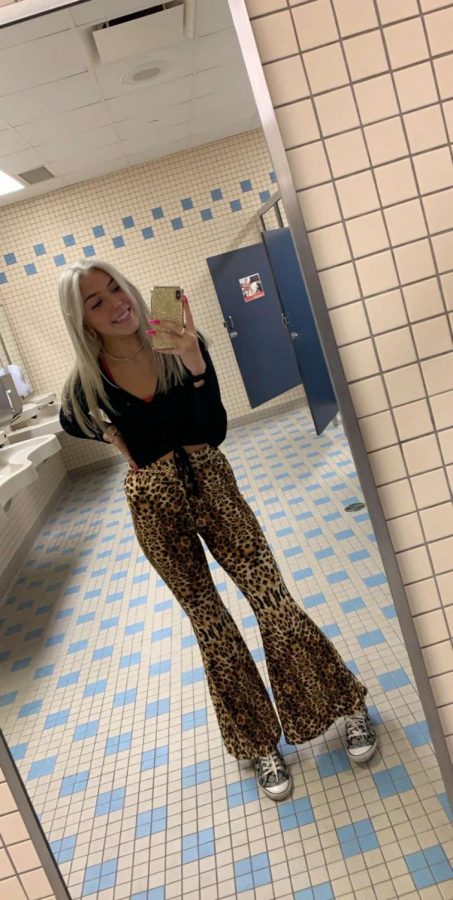 
Junior Jenna Wallace wears black because she is a junior. Freshmen wear white, sophomores wear grey, juniors wear black, and the seniors wear red. She is wearing a black long sleeve $, cheetah pants $15, coach shoes $45.