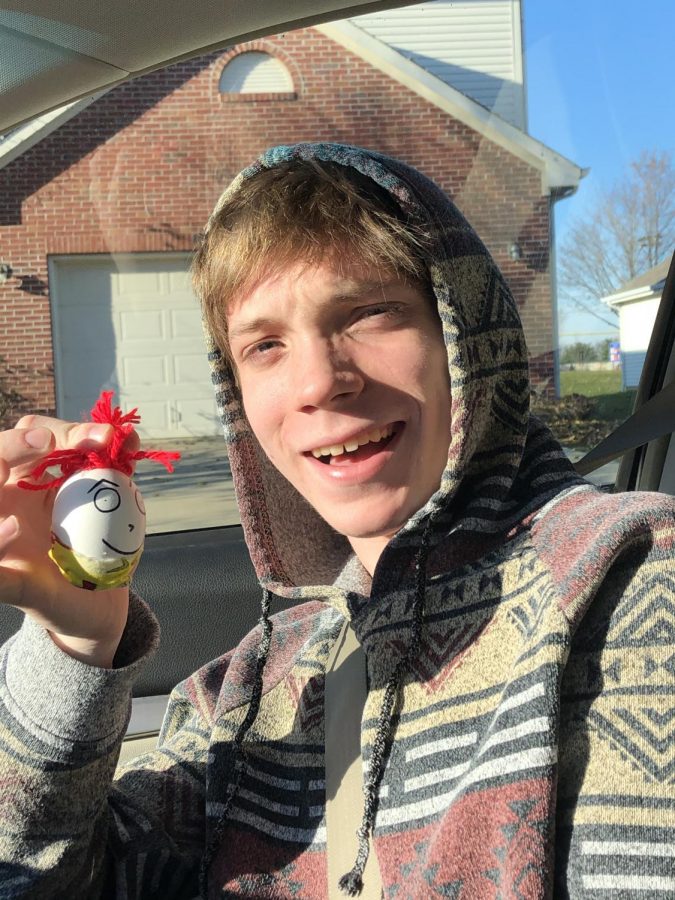 Junior Trey Warren hold his baby egg, which was decorated with red string and sharpie.