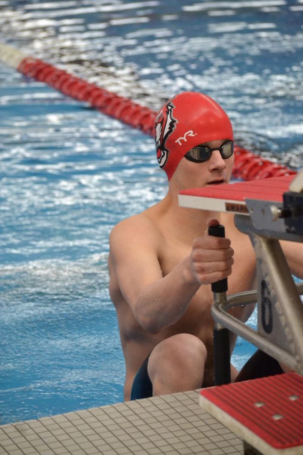 Sophomore Logan Aryes prepares for his start in the 100 backstroke. He placed third in finals. Thinking about how many stroke Im going to take and how many underwaters I will be doing reduces stress and clears your mind, Aryes said.