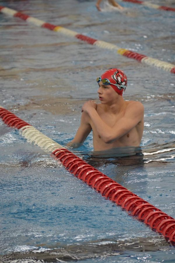 Freshman Connor Carlile watches his teammates race from the warm down pool.