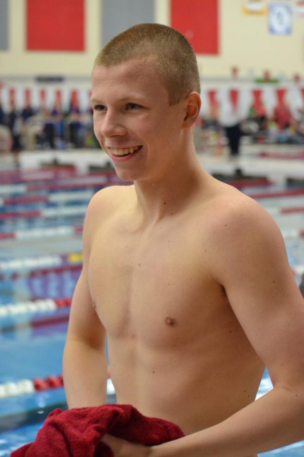 Sophomore Kyle Ponsler smiles as he walks out onto deck for the 400 freestyle relay. Breaking the pool and school record was just awesome, Ponsler said.