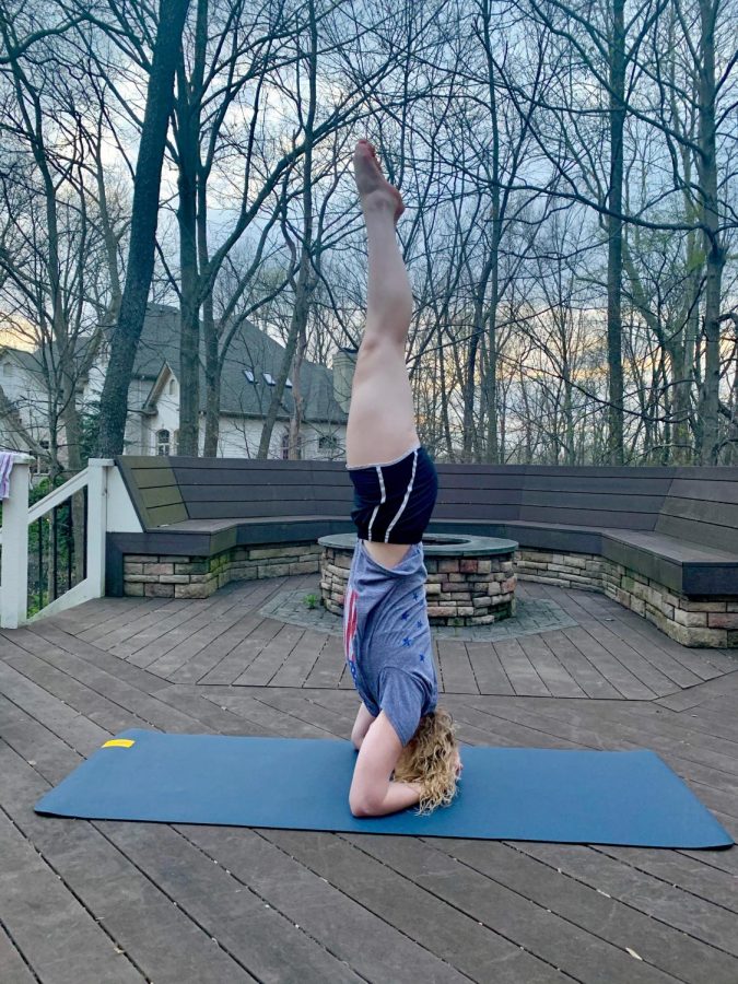 Junior Natalie Bryan does yoga on her back porch to give herself fresh air and a break from working on school work.