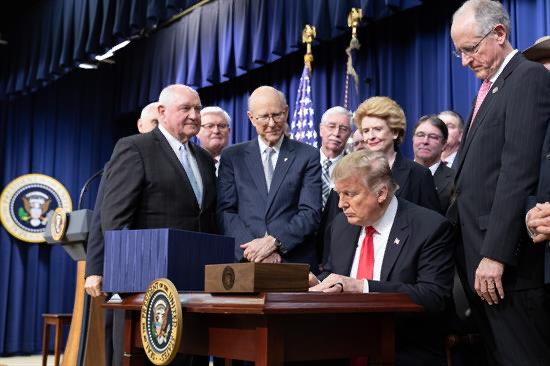 President Trump on Dec. 20, 2018, signs the 2018 Farm Bill in Georgia while surrounded by national and state level officials.
