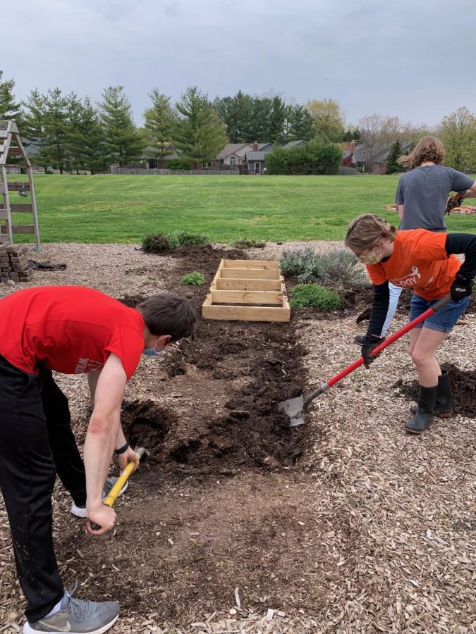 Seniors Dylan Parodi, Izzy Alexander and Mia Driskell work to dig a hole for the new sensory pathway frame. Sensory pathways are known to increase motor skills and a sense of balance and provide an outlet for stress relief. 