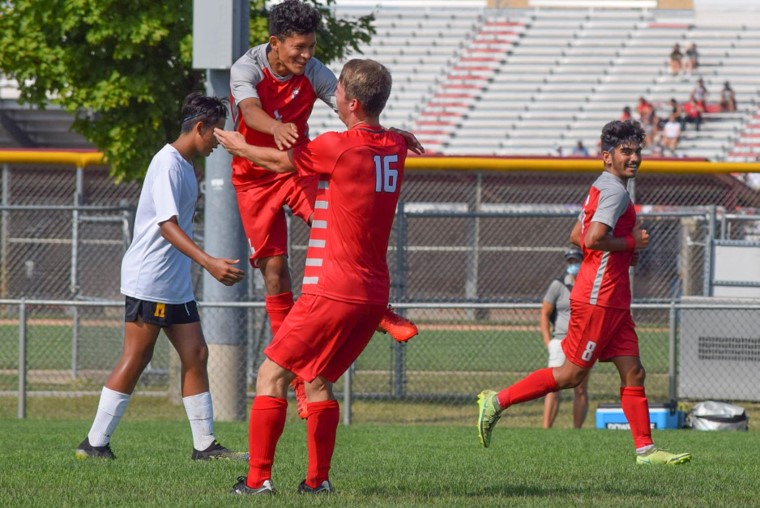 Junior Aywan Ishaq smiles while Sophomores Ashton Slater and Kevin Davalos celebrate after scoring a goal. The JV team defeated McCutcheon 7-0. 