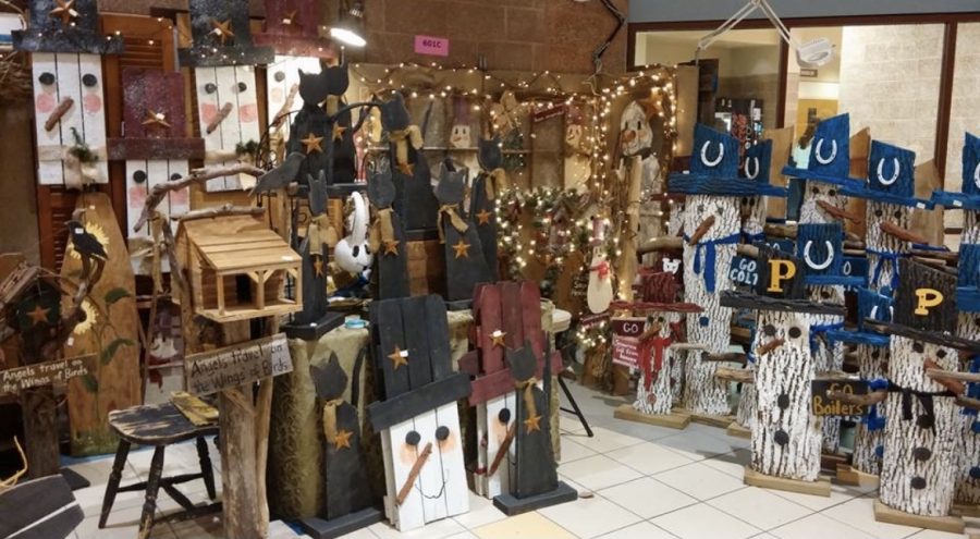 Decorative wooden pieces such as snowmen and cats sit in one of the cafeterias and are available for purchase at a vendor booth during a previous Christmas in October craft fair. 