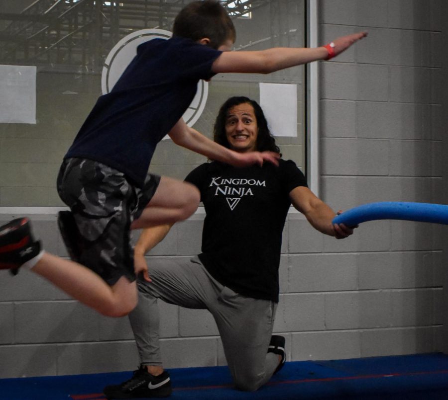 Chase Carlson, a fourth-grader at Maple Glenn Elementary, flies through the air after launching himself from the trampoline, aiming to go over the pool noodle Gil was holding at the Pro Ninja Clinic. The Pro Ninja Clinic took place on Feb. 25 at Ultimate Ninjas Indianapolis.
