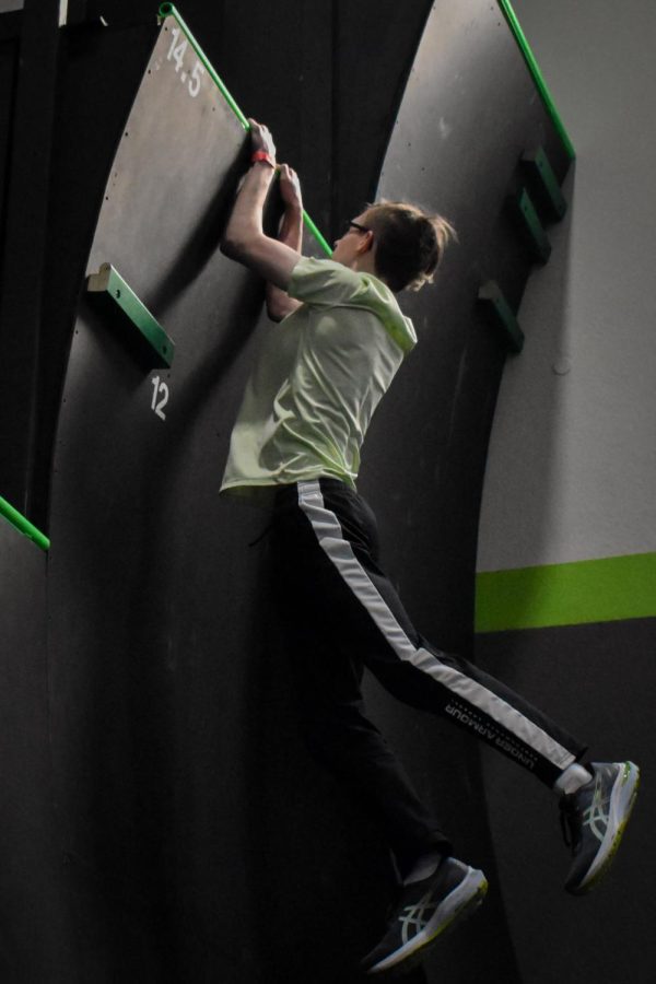 Charlie LaGue, an attendee of the clinic, holds onto the top of a ramp that was 14.5 feet tall, shortly before he pulled himself onto the ledge at the Pro Ninja Clinic. The Pro Ninja Clinic took place on Feb. 25 at Ultimate Ninjas Indianapolis.