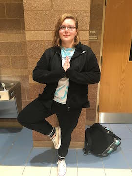 Sophomore Rosie Nieten practices her tree pose for yoga club in front of the Aux gym, on April 20. Photo by Emma Russell. 