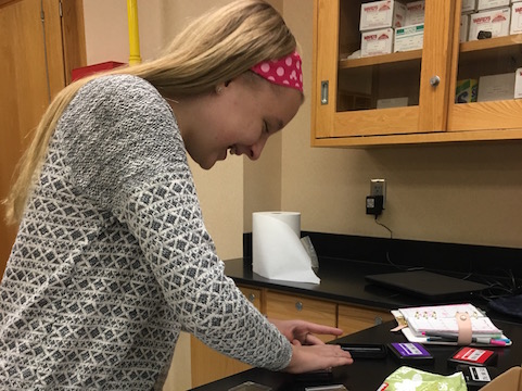 Freshman Sydney Suter laughs as she decorates her planner with stickers at Tiger Town Planners. Photo used with permission of Abigail Clone.