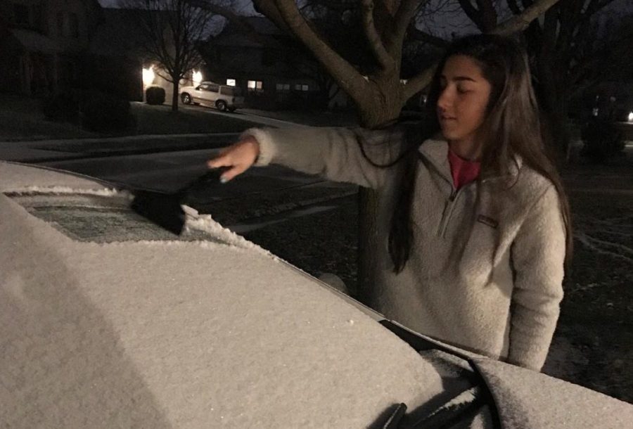 Junior Sonia Fuller clears her windshield before heading off to school on Dec. 5. 