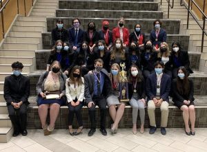 After the World School Debate team became state champions and the Speech and Debate team placed third overall at the State Debate tournament over the weekend, the team poses for a photo with their trophy.  