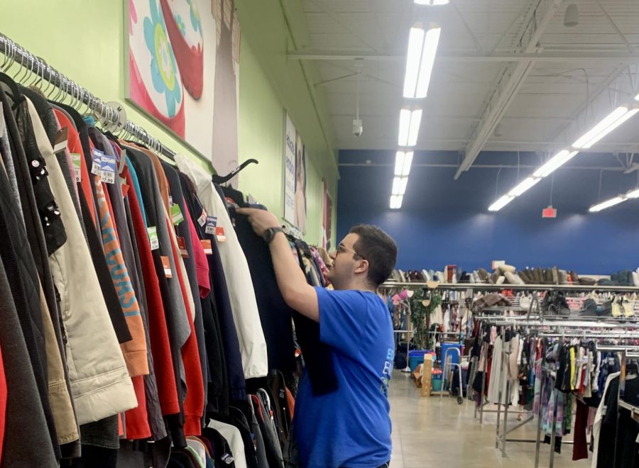 During his shift at Goodwill on April 22, senior Ben Crowe relocates a jacket that had been misplaced in the wrong section.