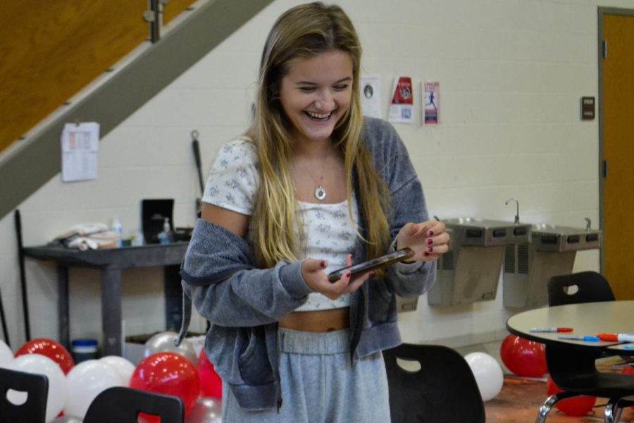 Brownell laughs in between taking photos for the class Instagram account that she manages. The student class officers, along with club leaders, contributed their work to make Homecoming week a success. The window decorating event took place Sept. 11.
