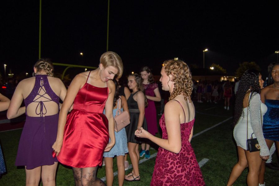 Junior Ava Haan shows their dress to freshman Kaitlyn Jacques. The homecoming dance had semi-formal attire. The homecoming dance took place on Saturday, Sept. 17.