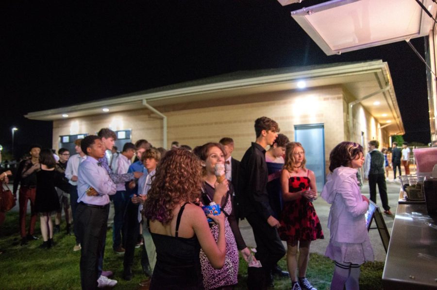 Students wait in line to order from the Crave ice cream truck, while some eat the ice cream they already received. To the side of the truck is a Kona Ice truck also providing students with food. The homecoming dance took place on Saturday, Sept. 17.