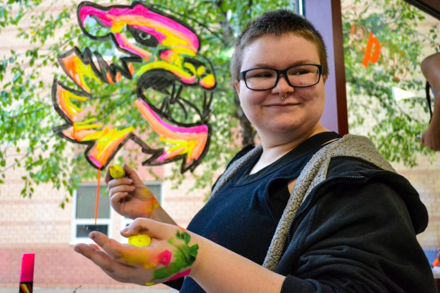Junior Rufio Frazier smiles while his peers compliment his artwork. The window decorating event took place Sept. 11.