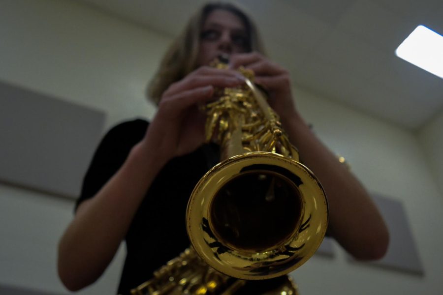 Junior Rayne Forbes warms up their soprano saxophone right before the concert. “[Jazz] lets me be myself when Im playing,” Forbes said. “ [Jazz] just lets me enjoy music a little bit more than other [genres].” The fall jazz concert took place on Oct. 10, 2022 at Fishers High School.