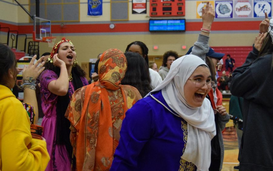 Junior Salma Moussaif engages in spontaneous singing and dancing with other students. The International Fair took place on Feb. 24 at Fishers. 