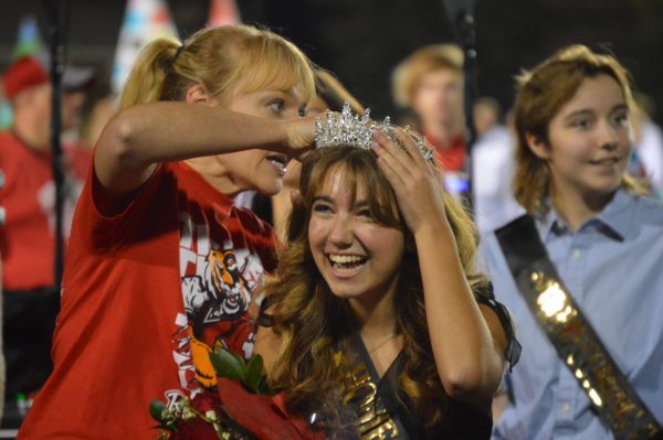 Senior Lily Sharp smiles and laughs while being crowned homecoming queen. Looking out and supporting Sharp from the stands was Junior Larkyn Muth, who looked back on the night and said, “The game was super fun, my choir got to sing the national anthem and one of my best friends won homecoming queen,” Muth said. “It was just an overall fun night!” The Homecoming football game was on Sept. 22.