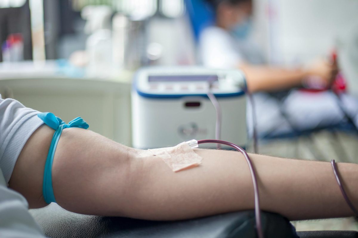 Blood being drawn from an arm in a blood donation facility.