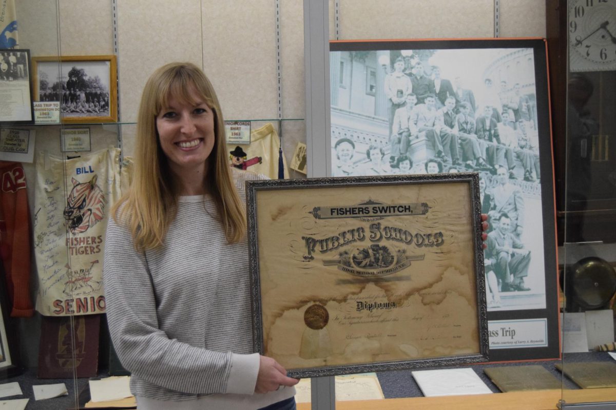 Jessica Irwin holds a 1897 diploma from Fishers Switch School before it was placed in the display case outside the main gym on Dec. 6.