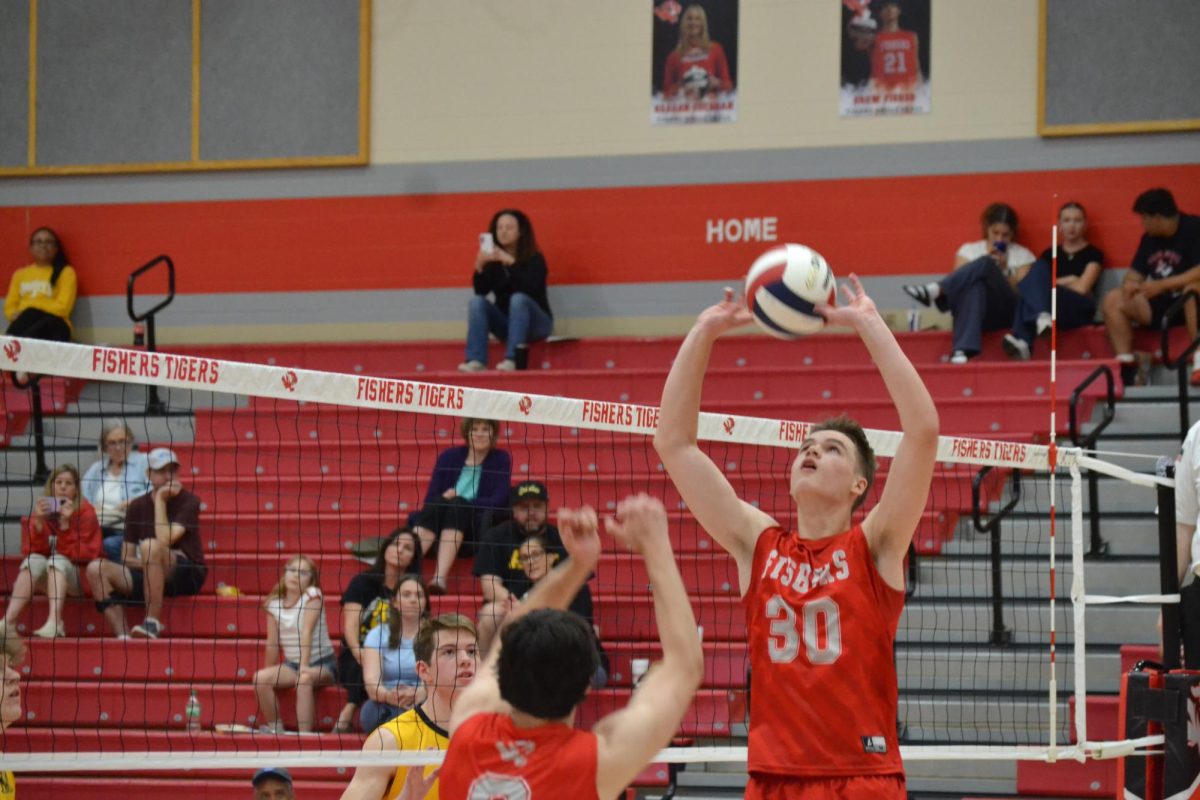 FHS varsity senior player JT Guler sets the volleyball in a game against Avon High School on May 8.