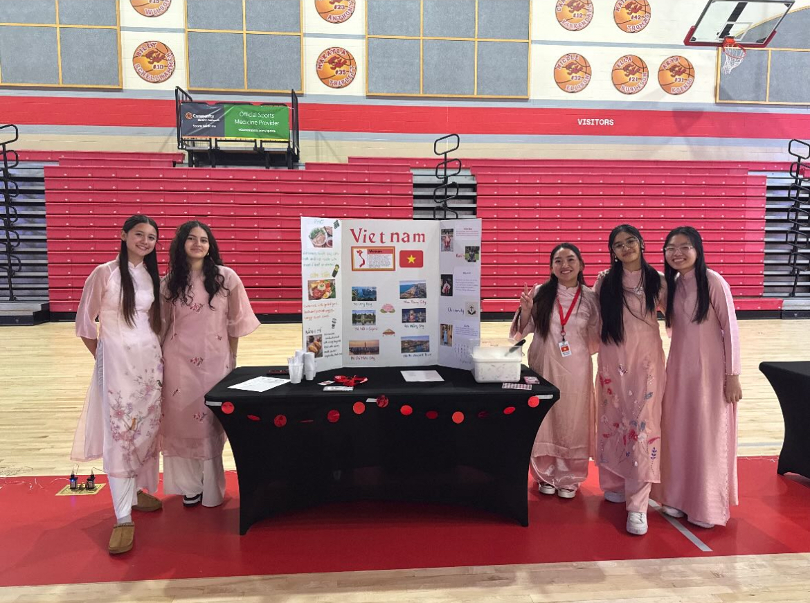 The International Show was held at Fishers High School in April 2025. Volunteers of International Show pose in front of Vietnam poster at the Fishers’ gym. From left to right, Jenny Nicoletti, Kayla Perez, Lena Le, Giselle Tran and Nhi Ho. Photo courtesy of Nhi Ho.  