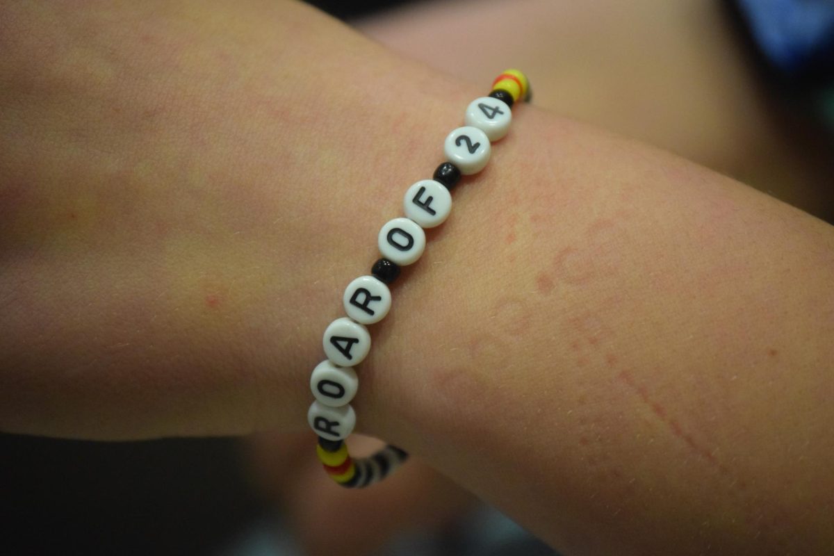 A bracelet of junior Delaney Prater that reads “ROAR OF 2024”. The bracelet signifies her role last year in the FHS marching band. 