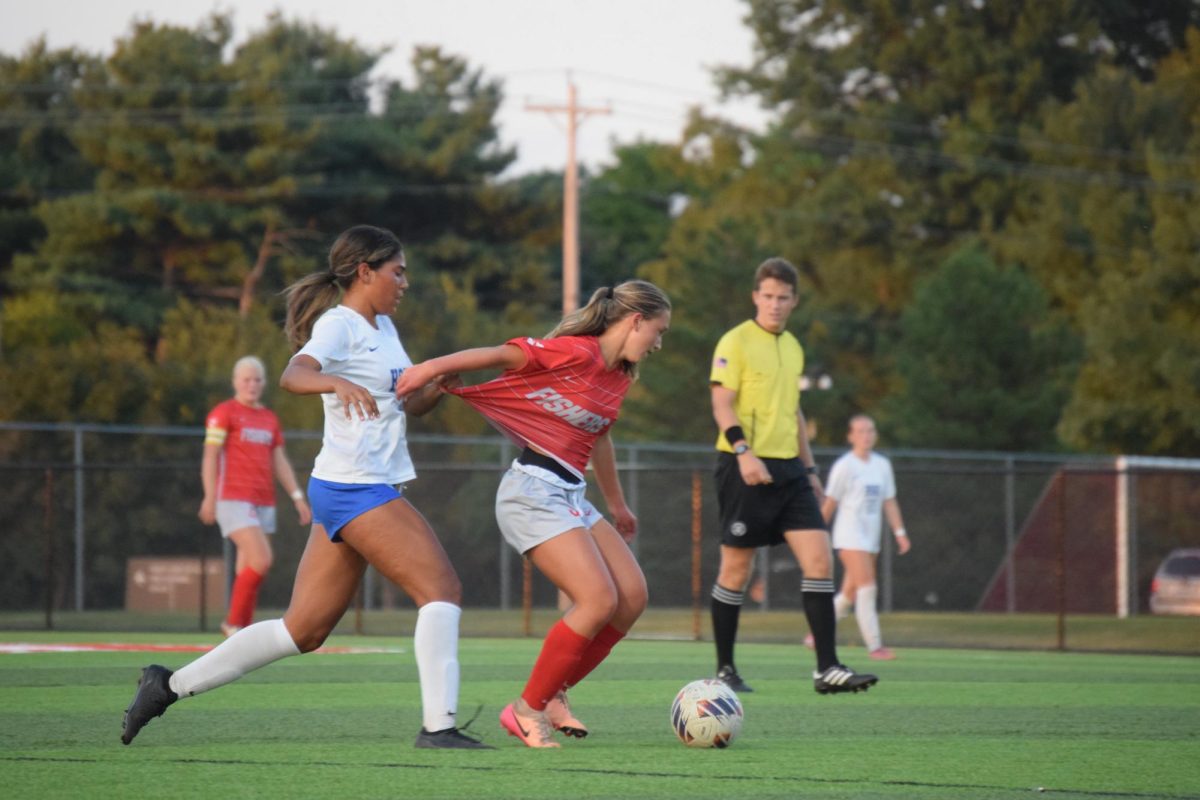 Sophomore Kendall Harris turns her back to HSE as her jersey’s pulled from behind. Harris is a swing player, joining the game after playing with JV earlier Wednesday night.
