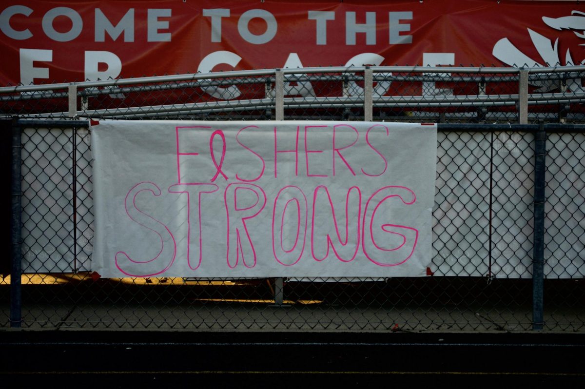 Poster with “Fishers Strong” written on it hangs in front of the student section at the pink out themed game on Friday, Oct. 4 at Reynolds Stadium.  