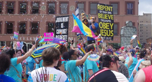 Pride parade walks downtown Indianapolis. Protesters of the parade are in the back while festival goers try to block opinionated signs. 