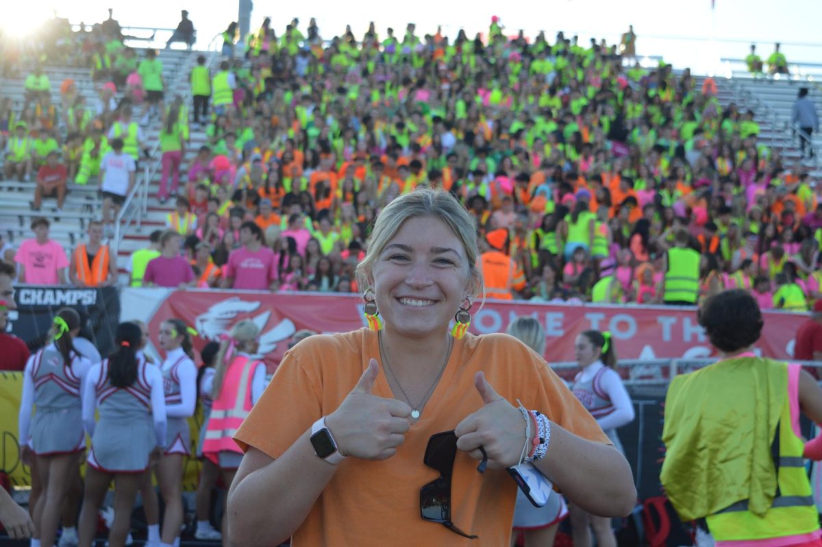Senior Tiger Cage member Olivia McNall posed in front of the student section on Sept. 26 at the neon homecoming game at Reynolds Stadium. Fishers played Avon High School and won 29-15.