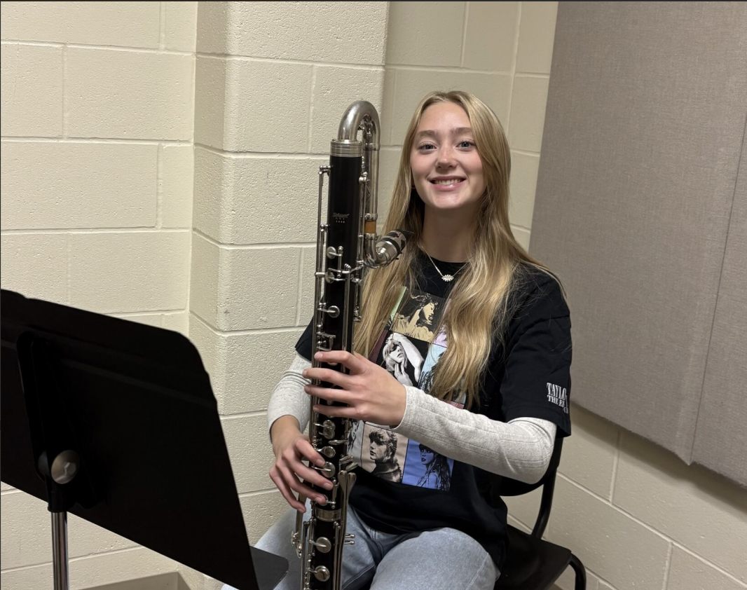 Flute player Aubrey Day next to an Eb Contra alto clarinet. This instrument is just under four feet tall. It plays even lower than the common bass clarinet. 