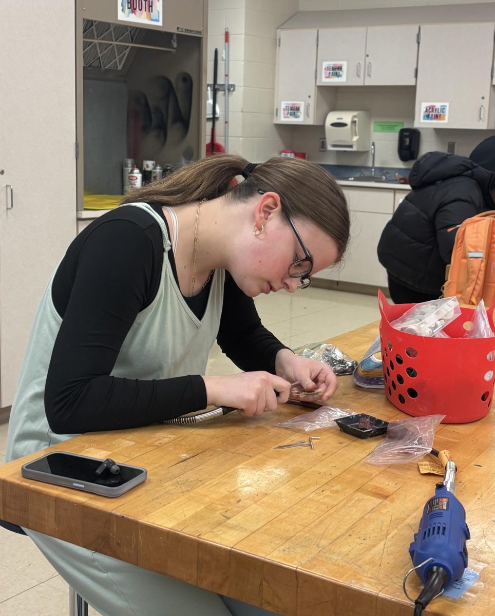 Sophomore Olivia Hatton finishes the final touches on her necklace pendent during jewelry class. Hatton is creating this piece to complete a set with other pieces she has made this semester.
Photo by Morgan Greiwe.
