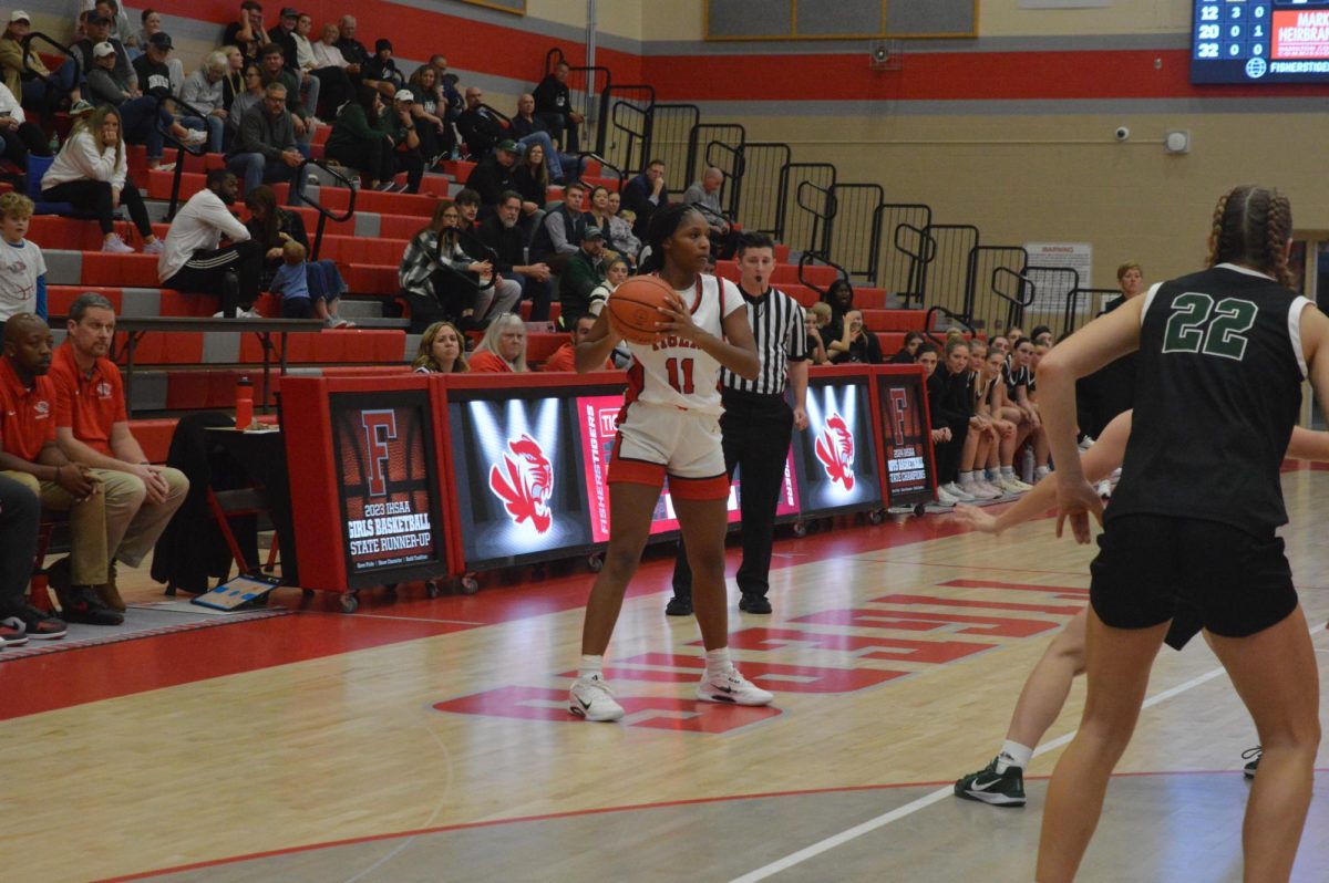 Senior Makayla Triplett holds the basketball in the Fishers main gym during a game against Zionsville on Nov. 25. Fishers lost 50-30. Photo courtesy of Jon Martin. 