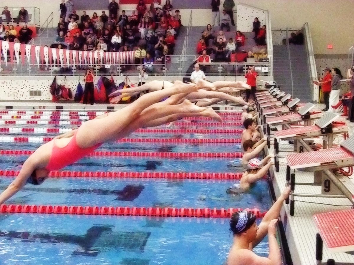 The girls varsity competitors in FHS’s swim meet against Caroll High School and Noblesville High School leap off their starting block on Jan. 24.  Photo by Maddie Davis. 