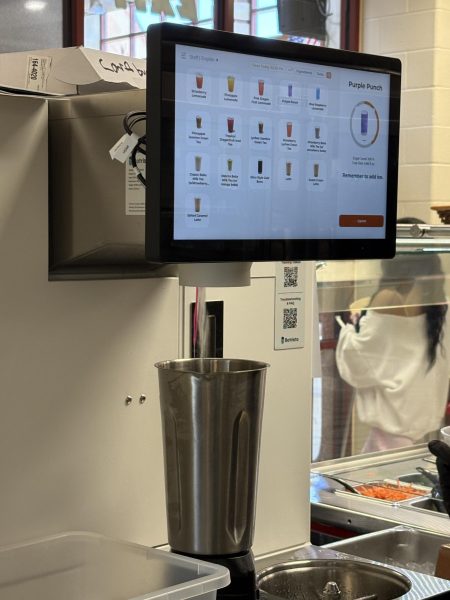 The new Botrista machine is an entirely programmed drink mixer. Any drink on the menu can be created with the push of a button. Café co-manager Katie Greenwood crafts a drink on May 7. Photo by Ella Kirkmeyer. 